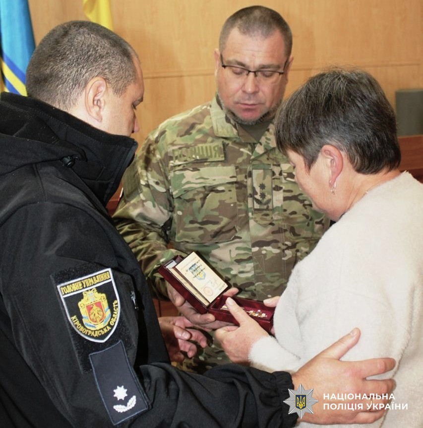 представники бригади Лють та поліції області вручають нагороду матері загиблого поліцейського