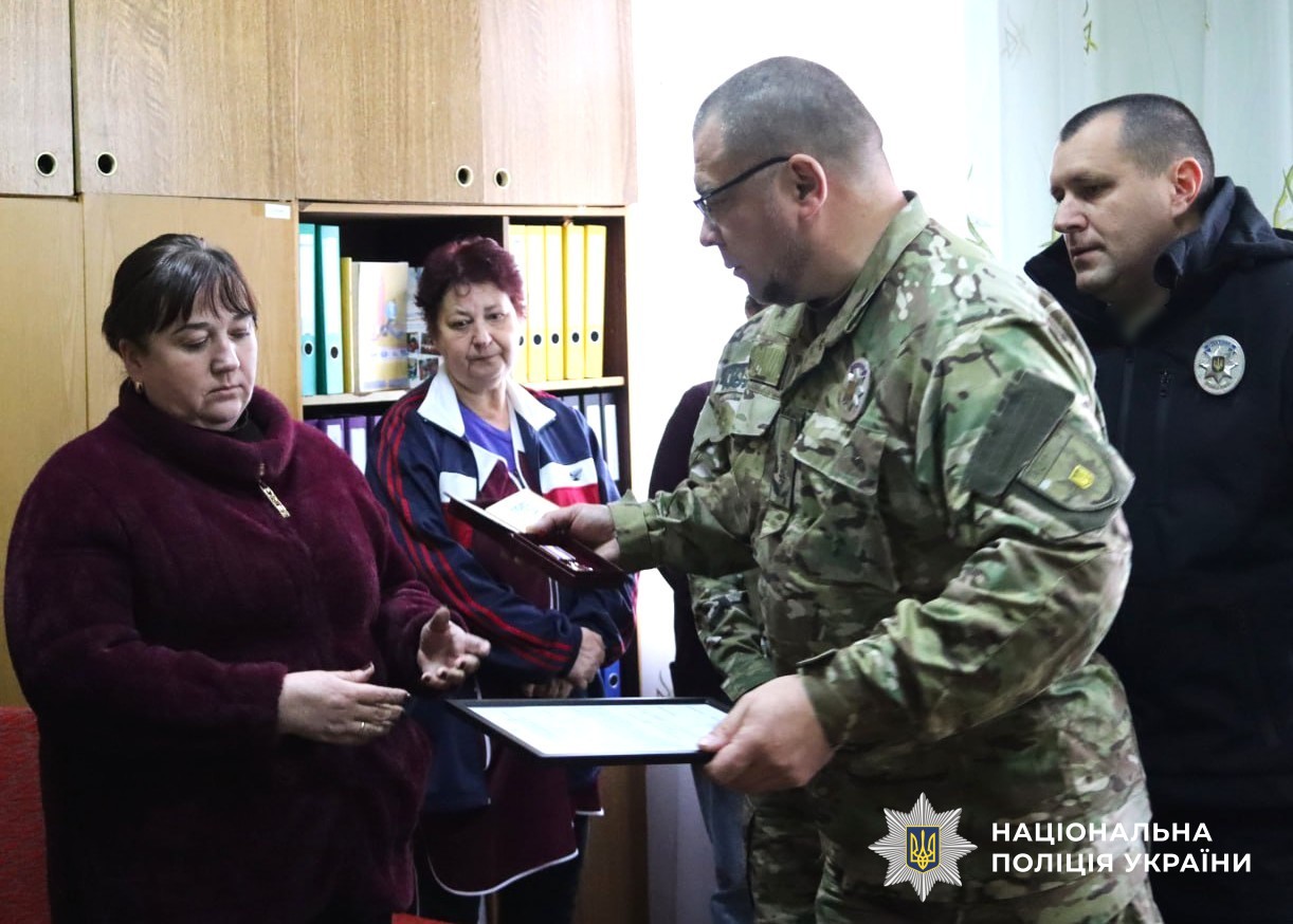 представники бригади Лють та поліції області вручають нагороду матері загиблого поліцейського