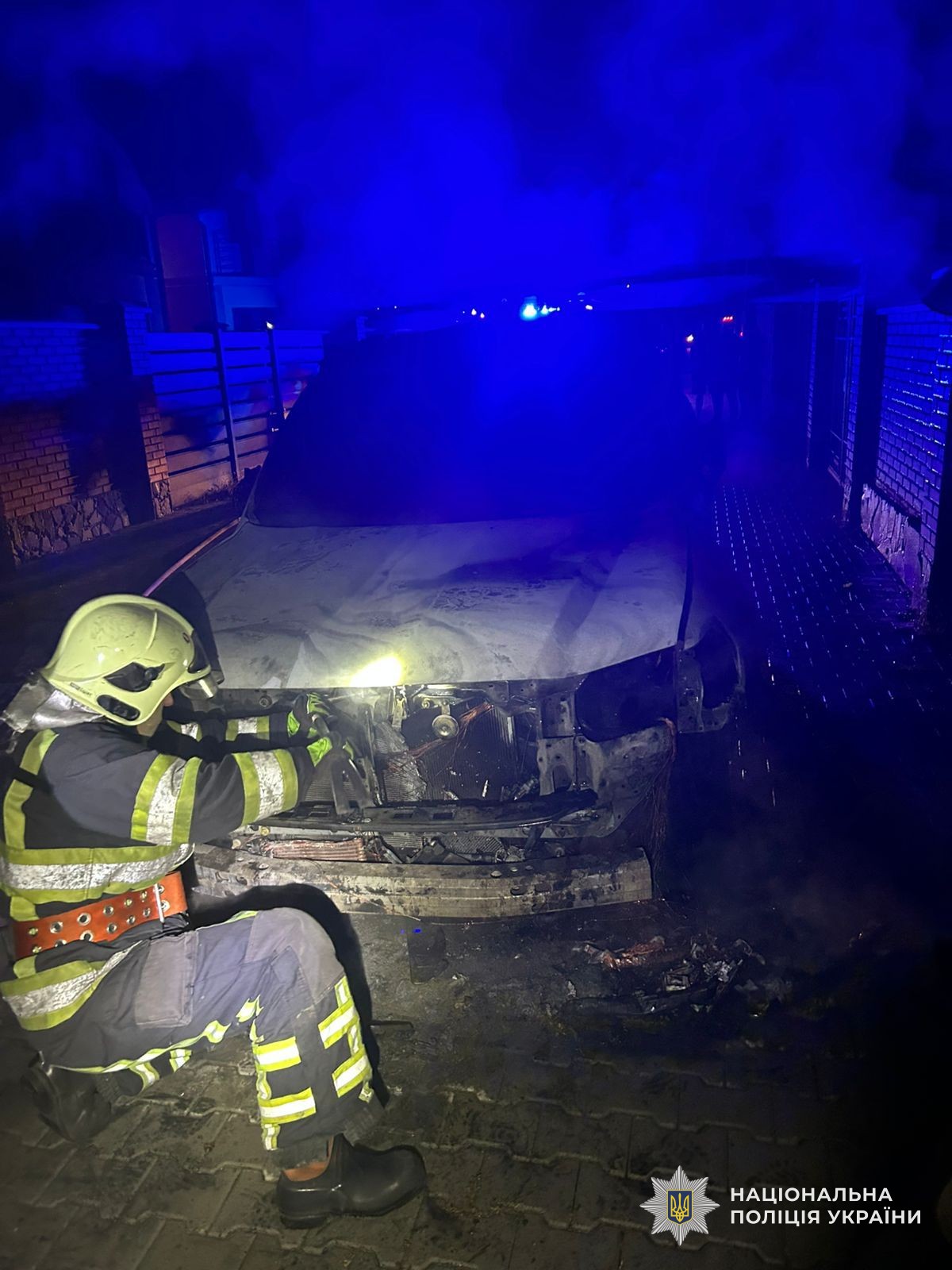Рятувальник оглядає пошкоджений вогнем автомобіль