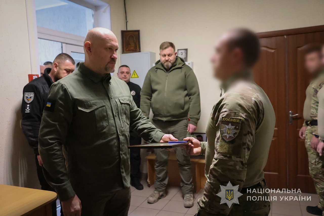 Керівник поліції Запоріжжя Артем Кисько вручає нагороду спецпризначенцю.
