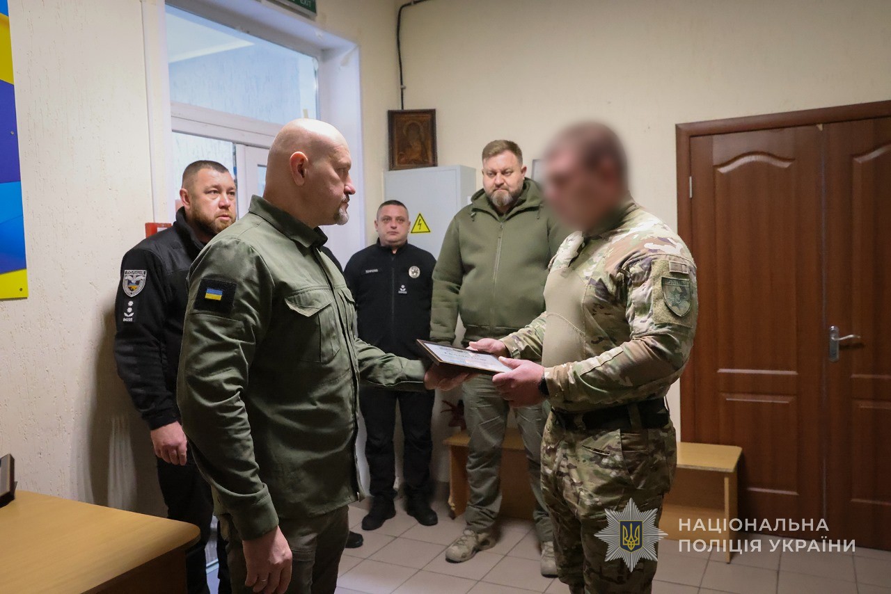 Керівник поліції Запоріжжя Артем Кисько вручає нагороду спецпризначенцю.