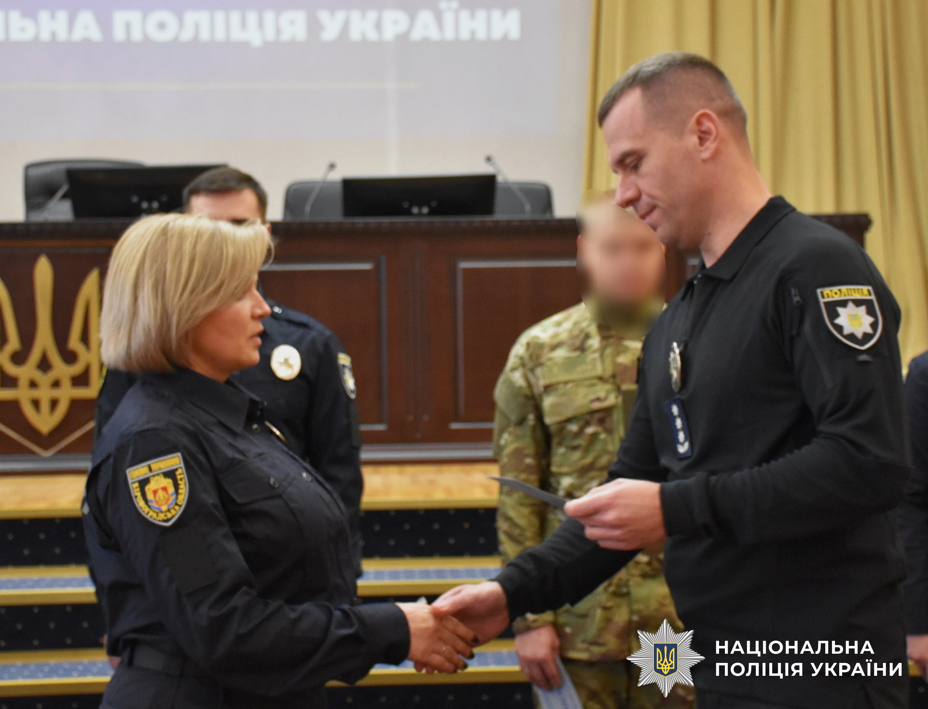 заступник керівника поліції вітає поліцейську зі складанням присяги