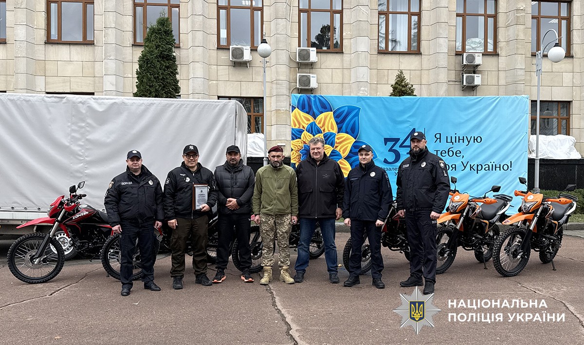 військовослужбовці та поліцейській позують на спільному фото біля мотоциклів