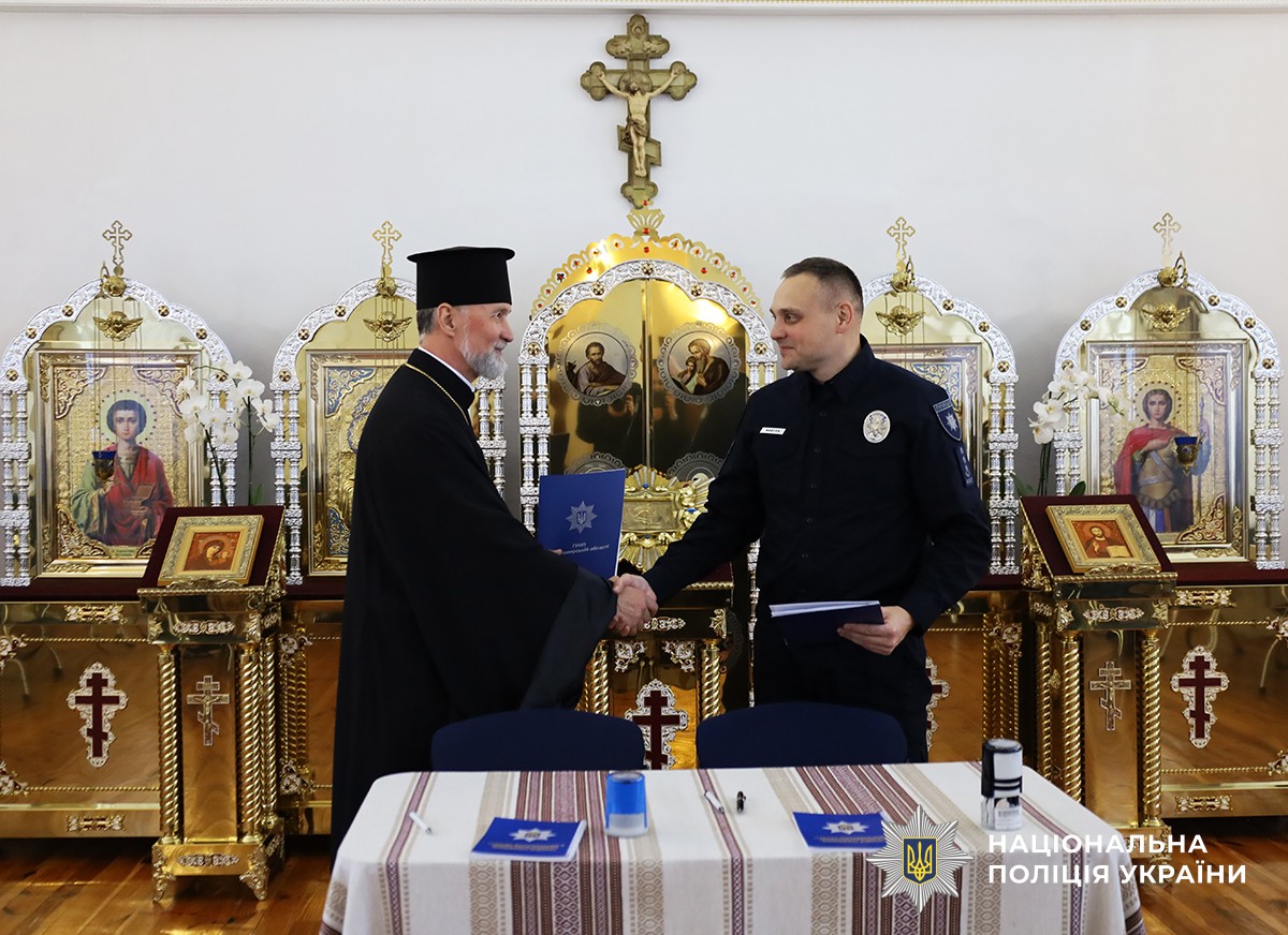 Отець Богдан і Олександр Ковтун тиснуть руки.