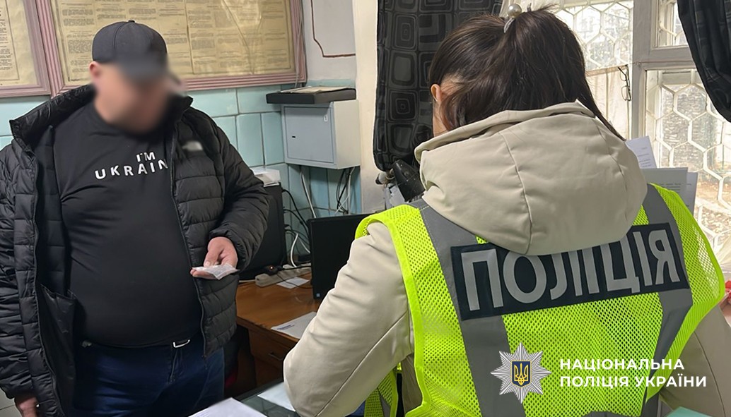 поліцейська спілкується з фігурантом у його службовому кабінеті.