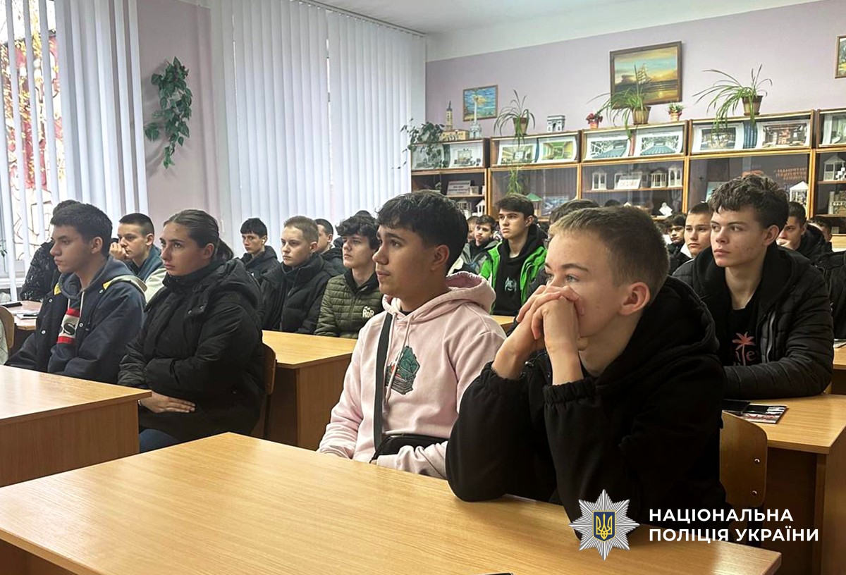 Першокурсники сидять за партами та уважно слухають.