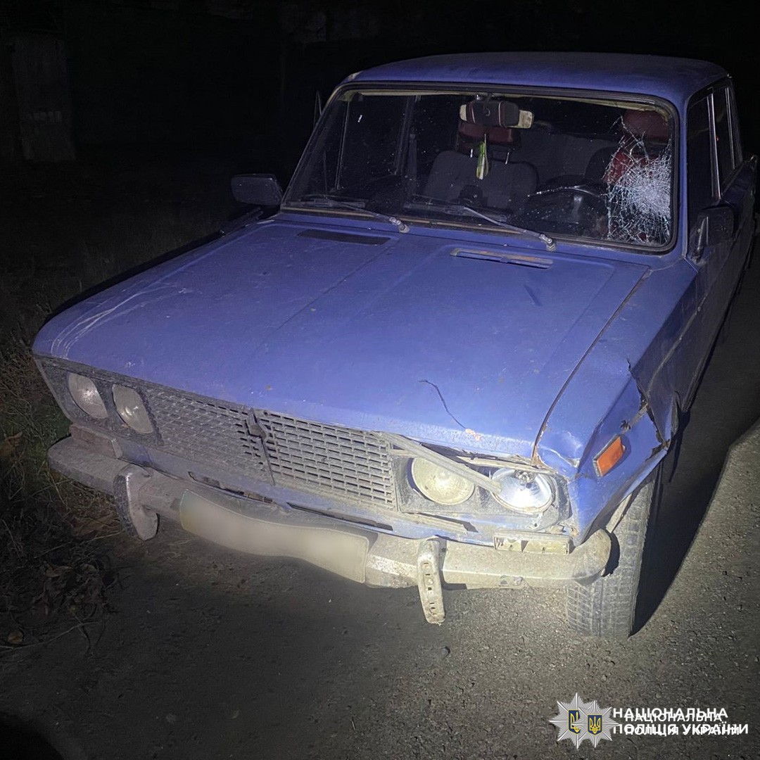 Пошкоджений синій легковий автомобіль радянської моделі з видимими ушкодженнями передньої частини, зокрема фари, бампера та лобового скла.