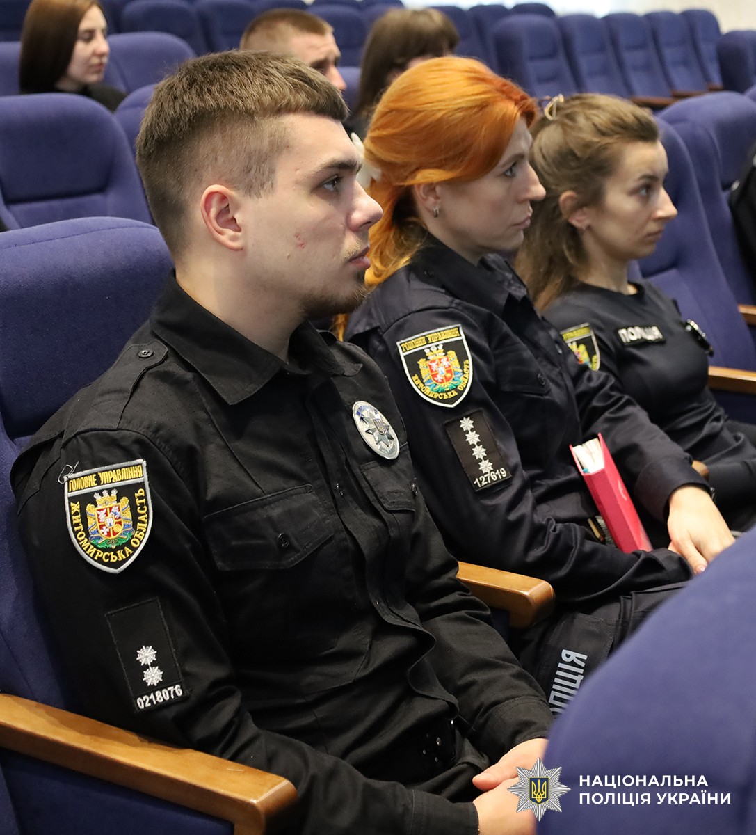 Поліцейські розташувалися на синіх стільцях в актовому залі, уважно слухаючи лекцію.