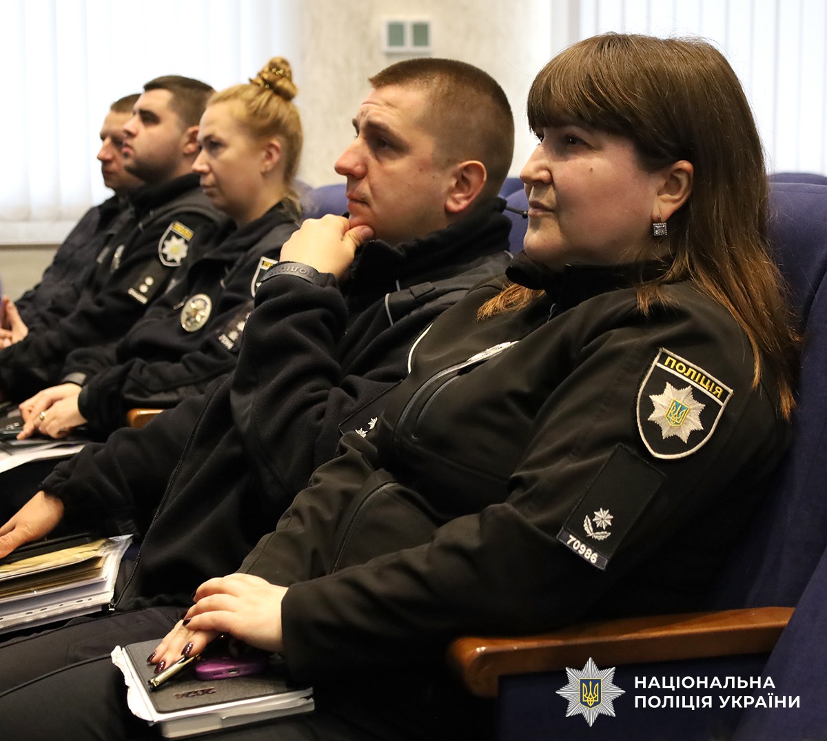 Поліцейські розташувалися на синіх стільцях в актовому залі, уважно слухаючи лекцію.