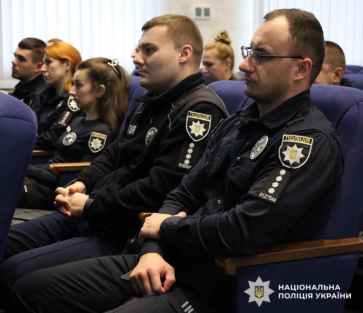 Поліцейські розташувалися на синіх стільцях в актовому залі, уважно слухаючи лекцію.