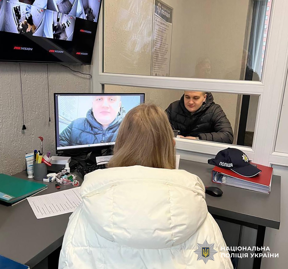 Двоє людей спілкуються через скло у кімнаті для затриманих