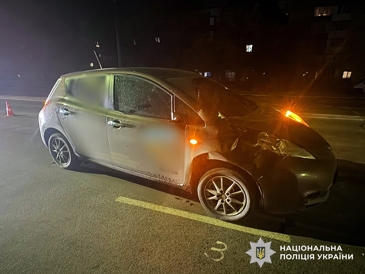 Легковий автомобіль із пошкодженнями передньої частини, який стоїть на проїжджій частині. Поруч виставлено попереджувальний конус.