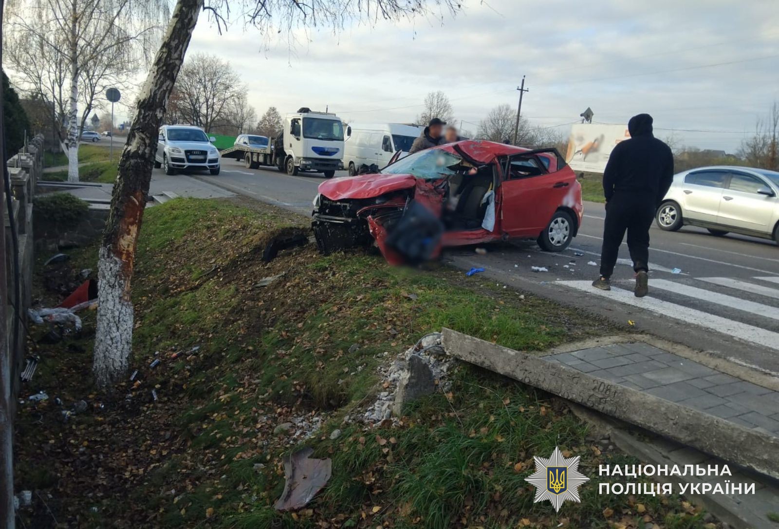 Пошкоджена внаслідок ДТП автівка, пошкоджені дерево та бетонна опора