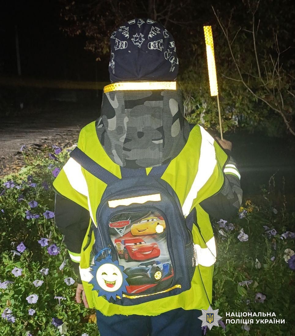 дитина у світловідбивному жилеті