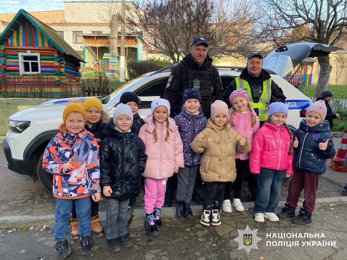 Поліцейські із дітьми поблизу службового автомобіля