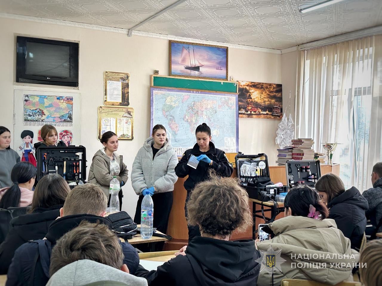 Поліцейська демонструє учням вміст криміналістичної валізи