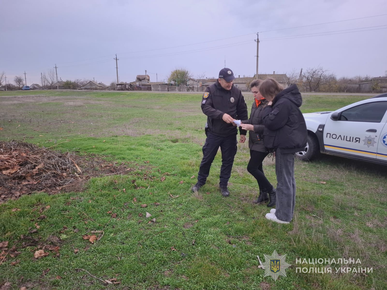 Поліцейський розповідає людям про заборону спалювання листя та трави