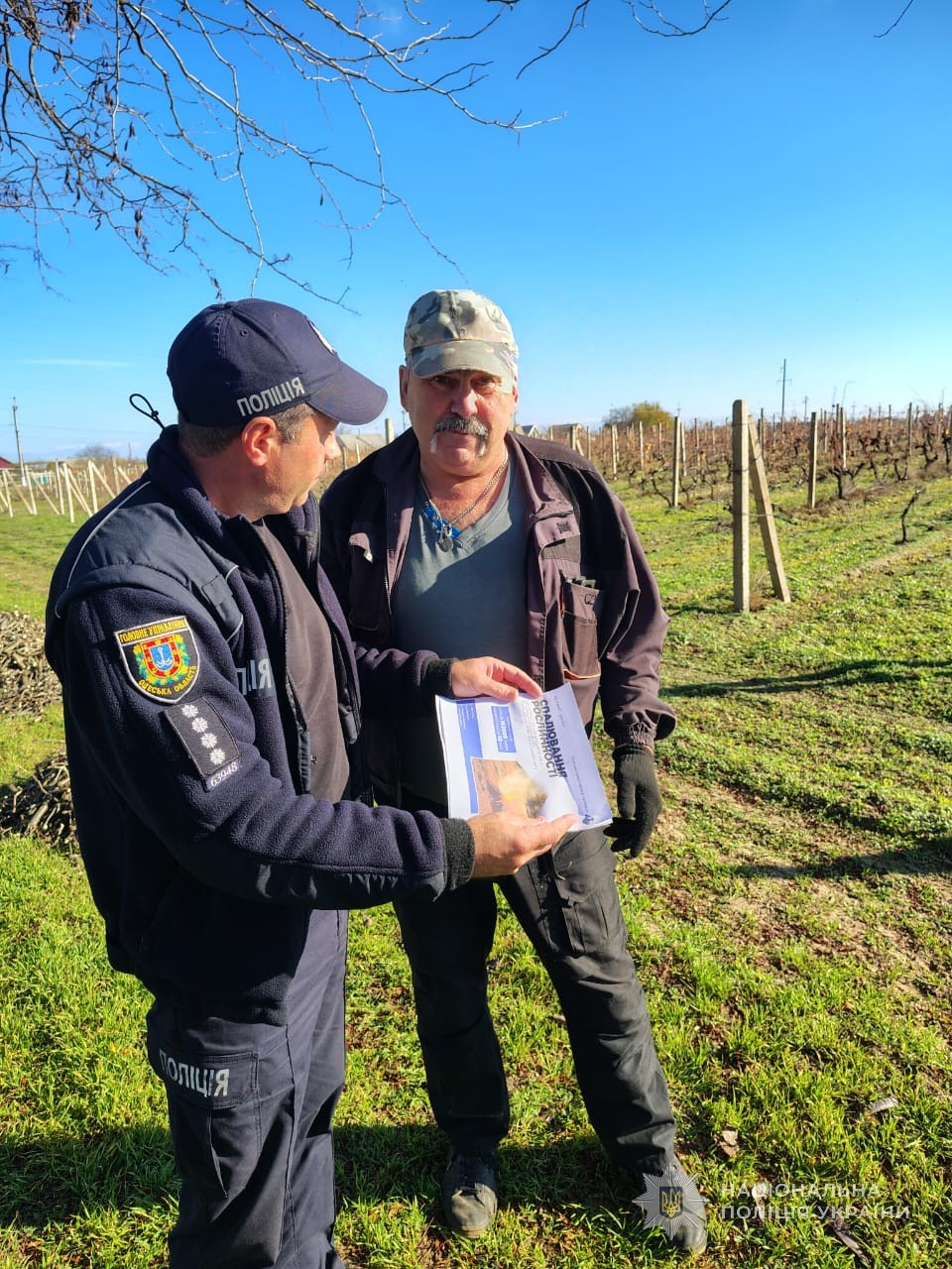 Поліцейський розповідає чоловікові про заборону спалювання листя та трави