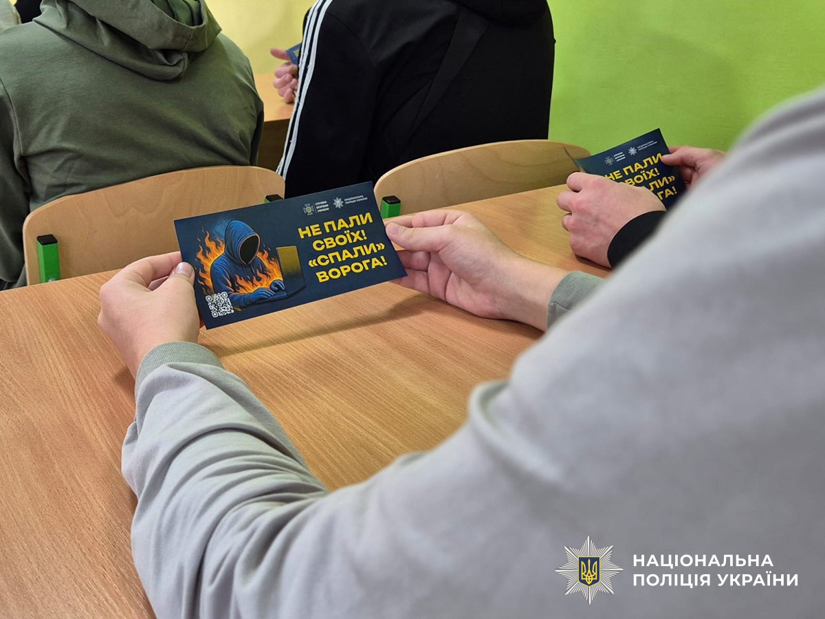 Листівка "Не пали своїх - спали ворога" в руках підлітка