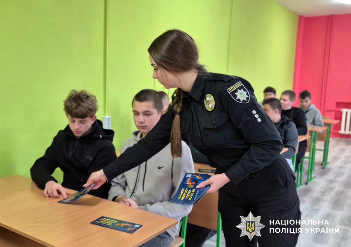 Поліцейська роздає студентам листівки