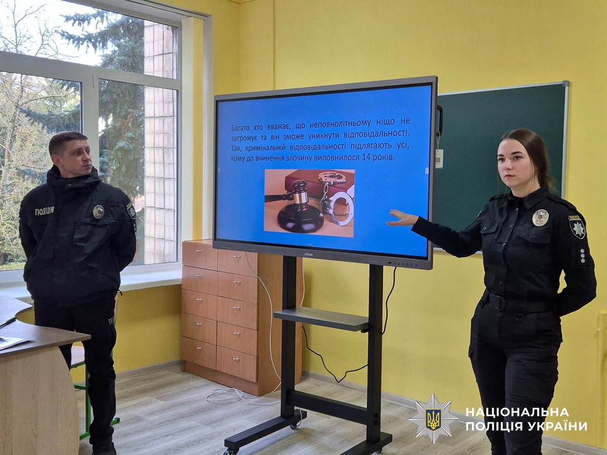 Двоє поліцейських стоять біля інтерактивної дошки з презентацією