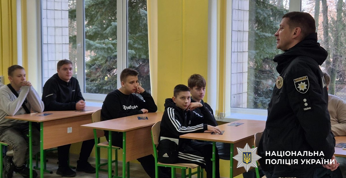 Студенти сидячи за партами слухають лекторів