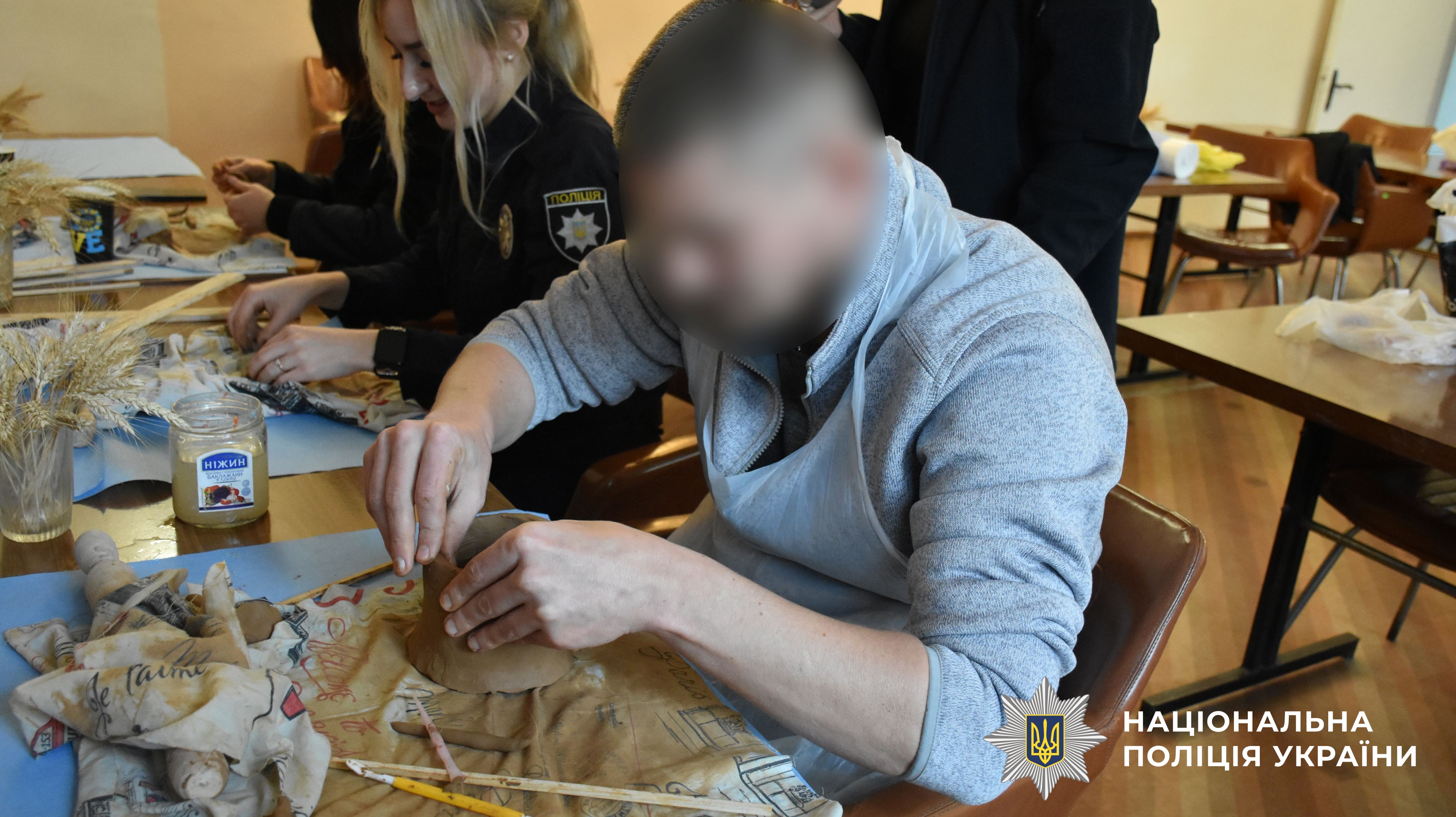 учасник заходу робить виріб із глини