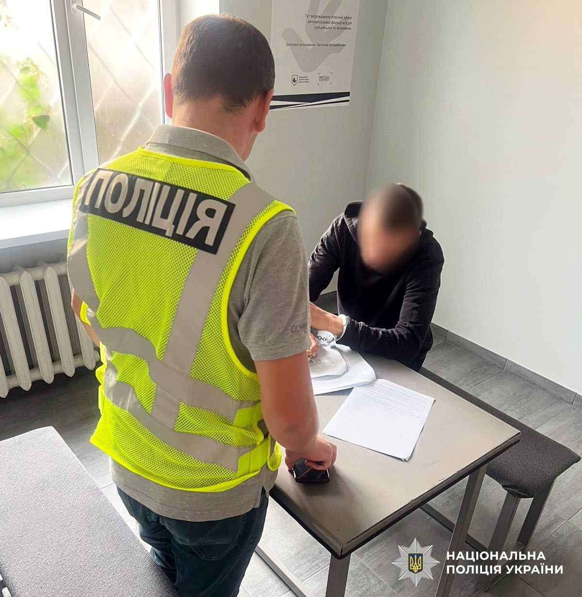 Поліцейський повідомляє про підозру фігуранту.