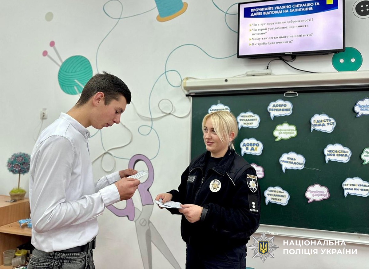 Поліціянтка взаємодіє з учнем під час заняття в навчальному класі