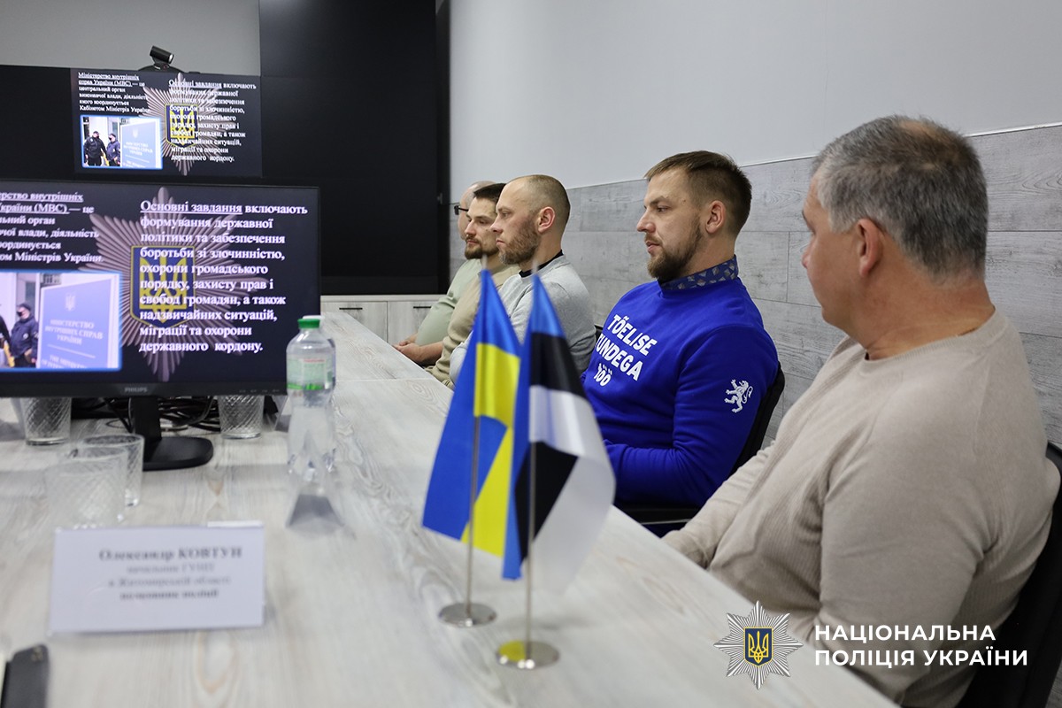 За столом у кабінеті сидять представники естонської делегації. На столі розташовані комп’ютери, а на фоні видно екран із презентацією про структуру поліції України.