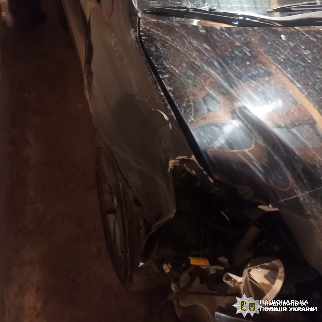 Передня ліва частина автомобіля з видимими механічними пошкодженнями: деформація крила, розбитий ліхтар, пошкоджене колесо.