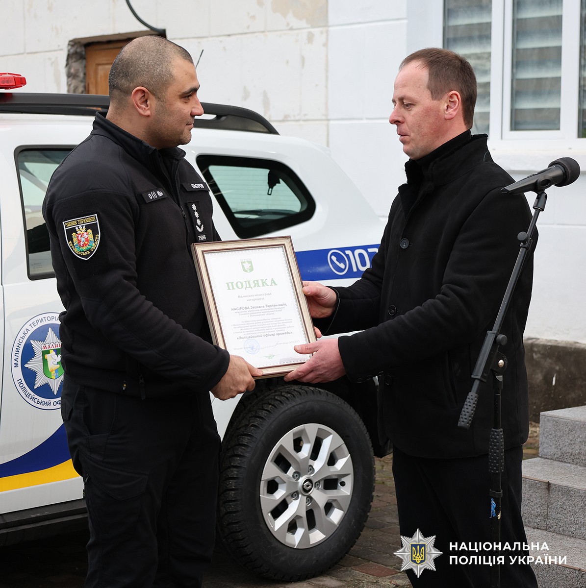 Голова громади вручає подяку поліцейському, на вулиці.