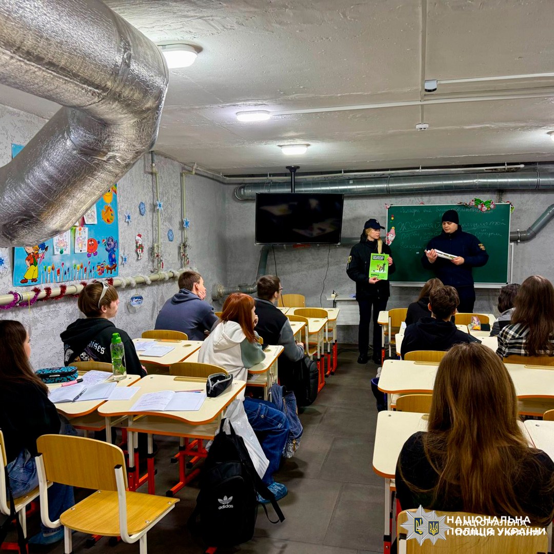 Поліцейський проводить заняття з безпеки для учнів у підвальному класі.