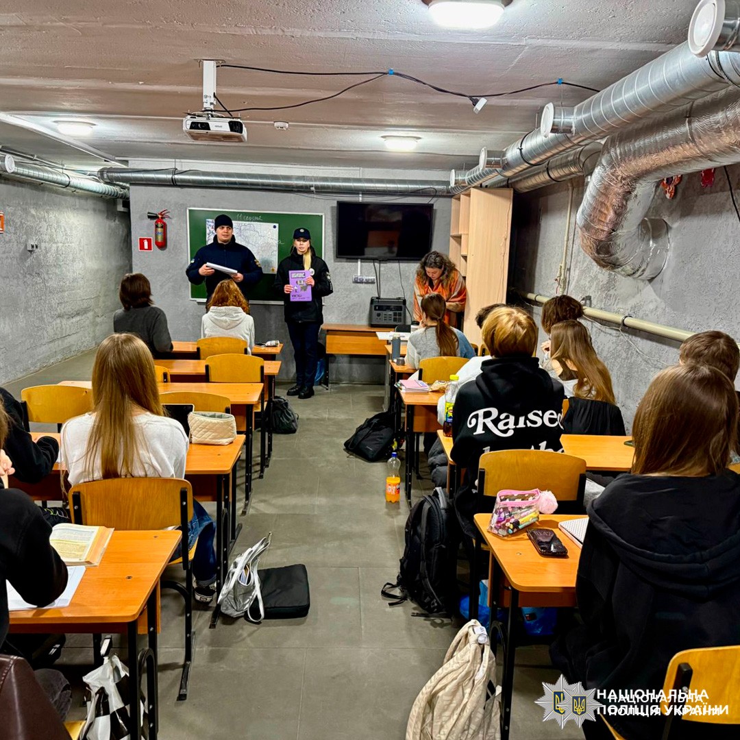 Поліцейський проводить заняття з безпеки для учнів у підвальному класі.