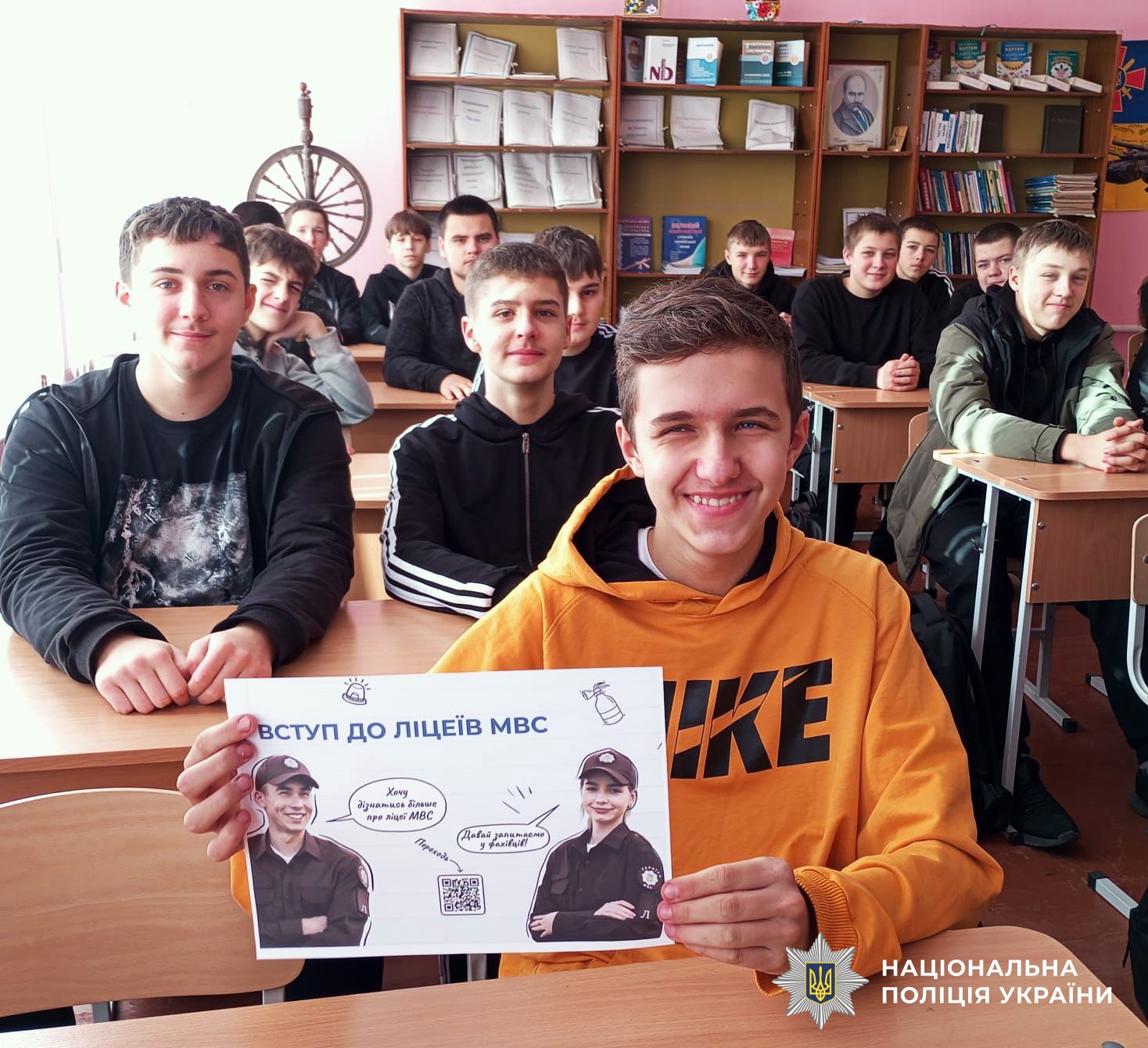 учень триває в руках рекламу щодо вступу до ліцеїв МВС. На фоні інші учні у навчальному класі