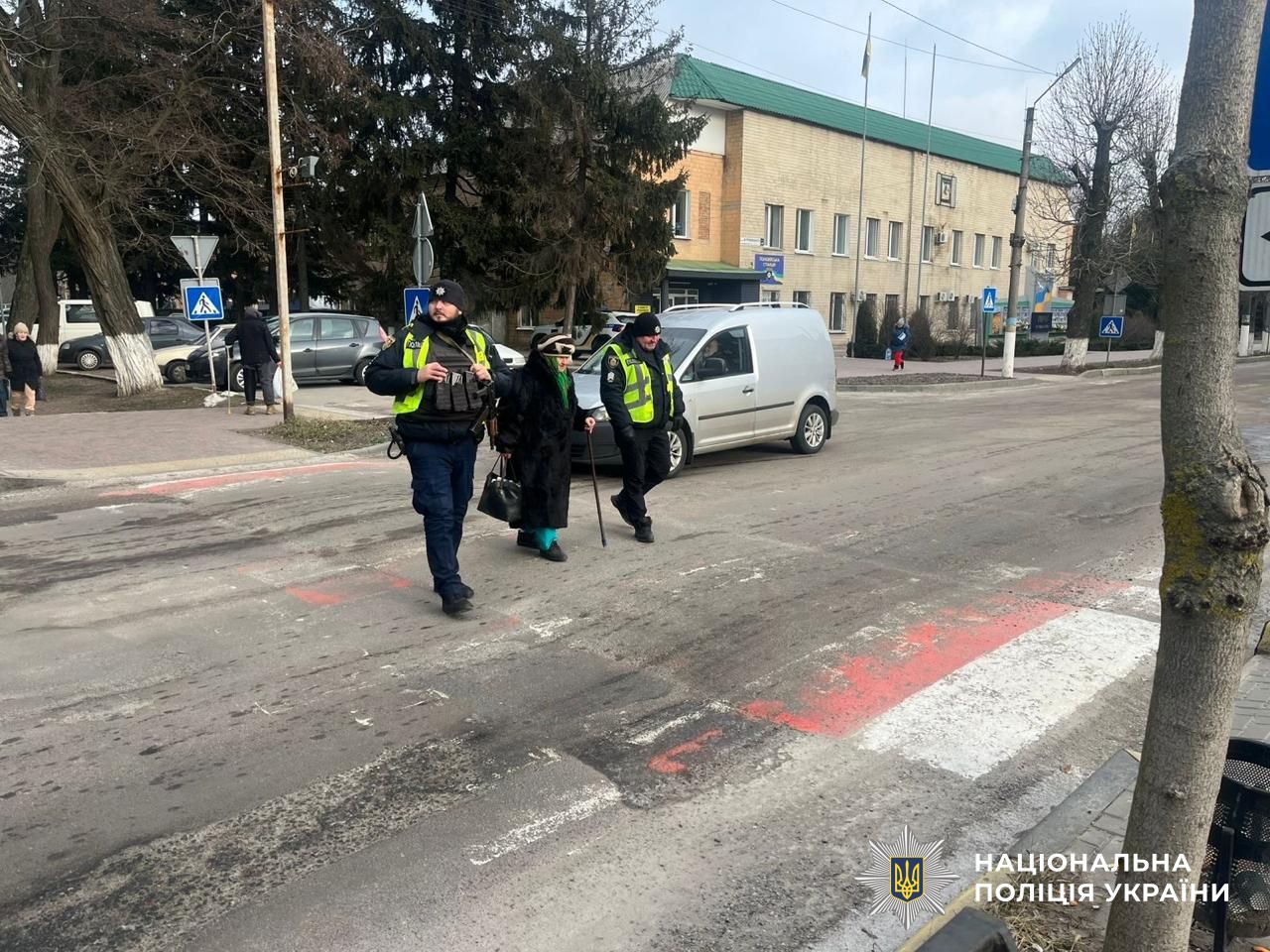 поліцейські переводять жінку через проїзджу частину