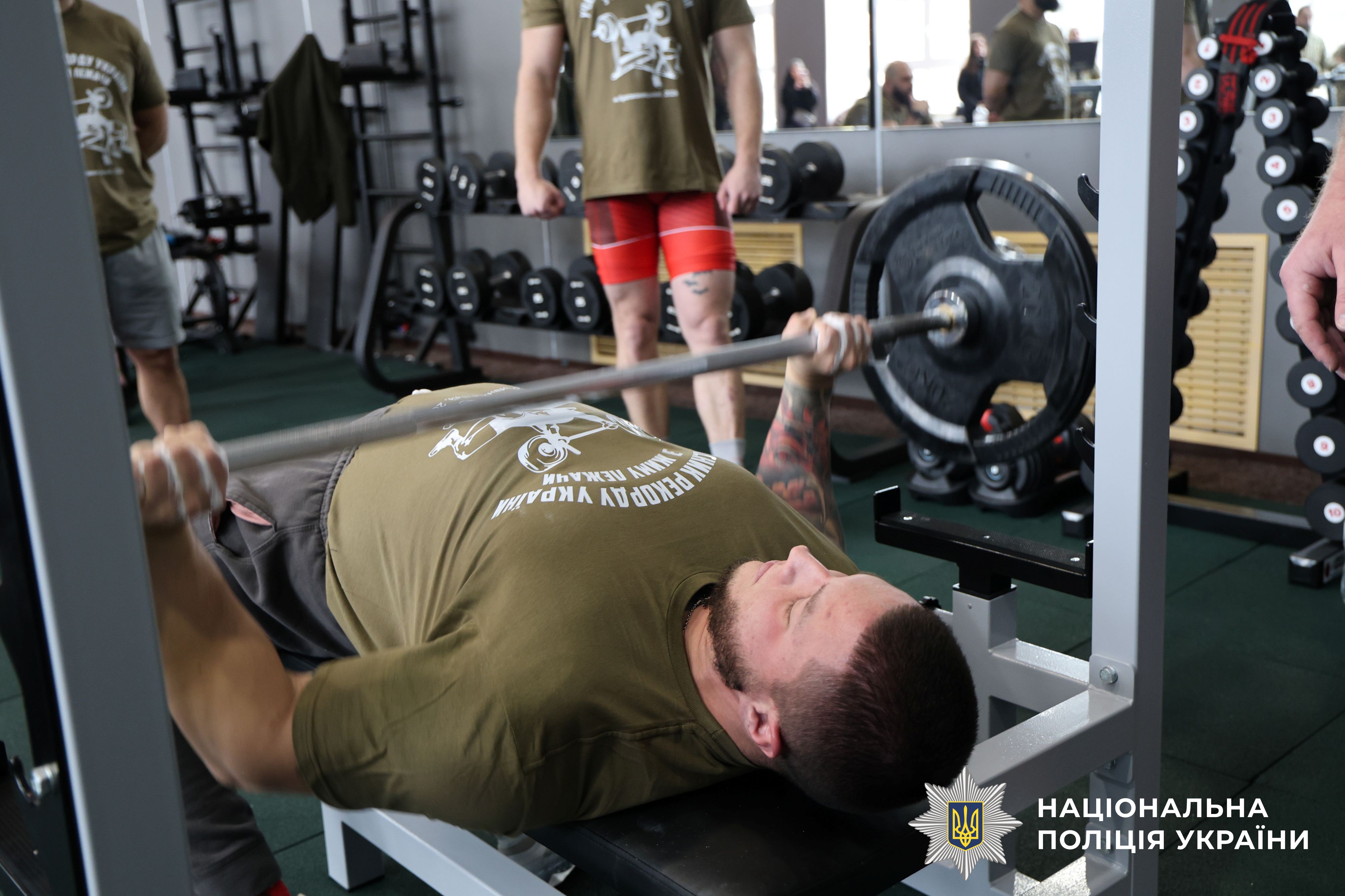 спортсмен виконує вправу "жим лежачи"
