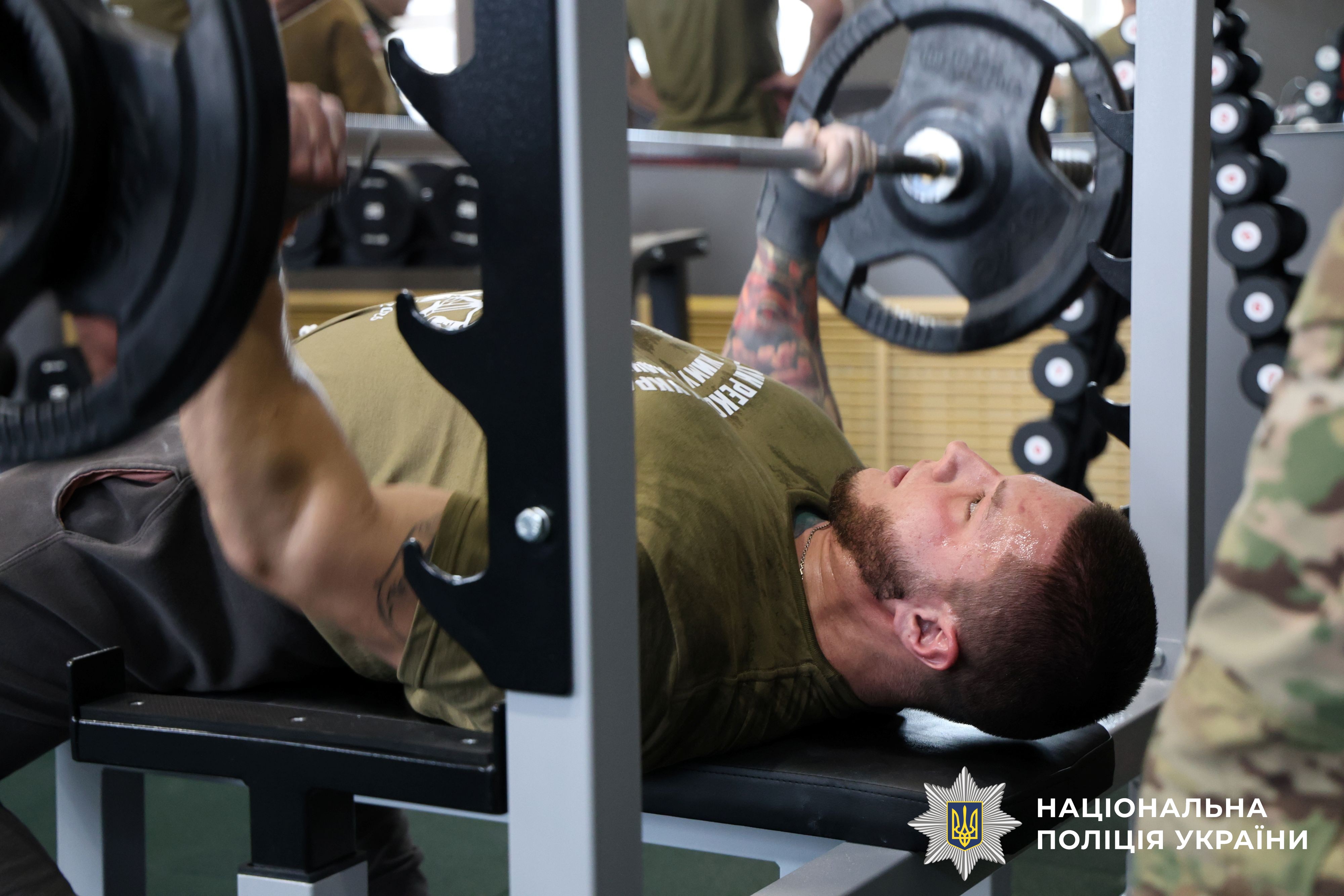 спортсмен виконує вправу "жим лежачи"