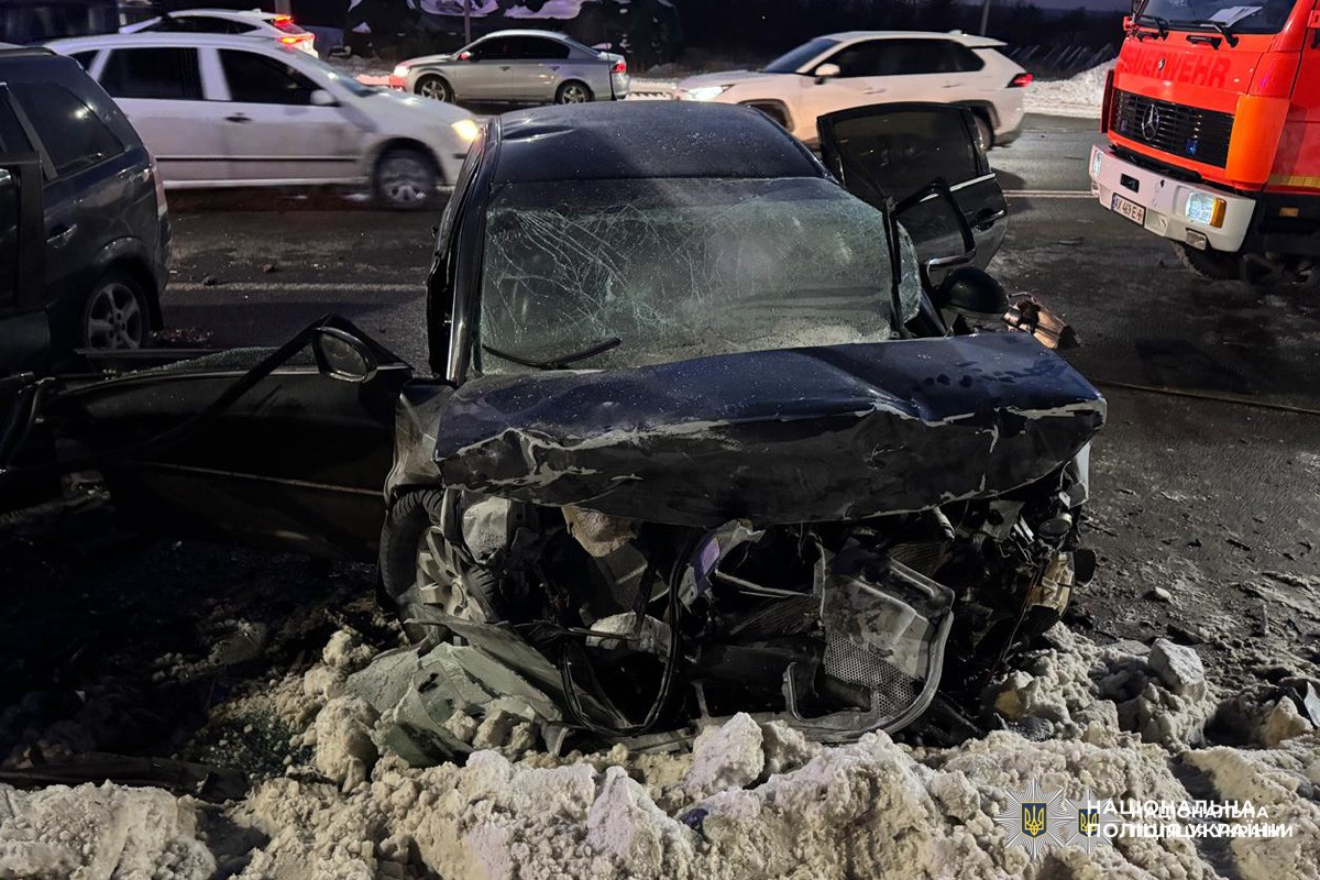 Сильно пошкоджений чорний автомобіль після аварії.