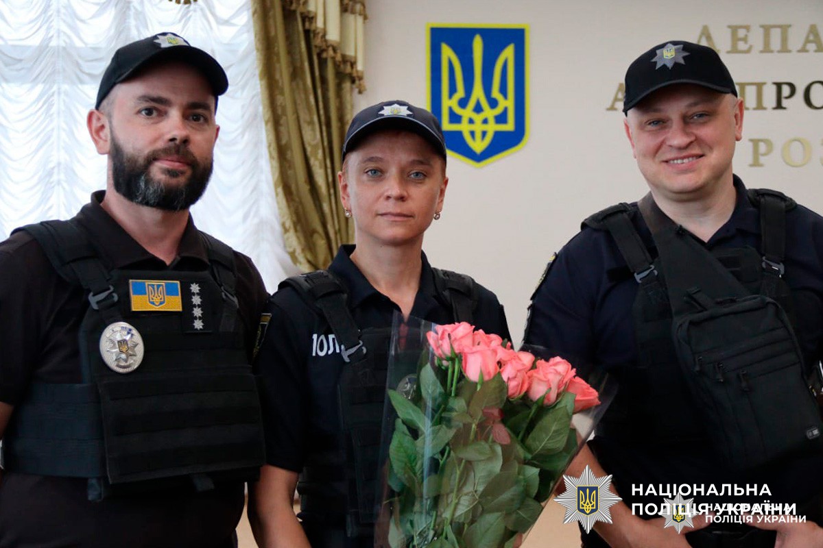 Офіцери Національної поліції України під час урочистої події, де колегу відзначають квітами.