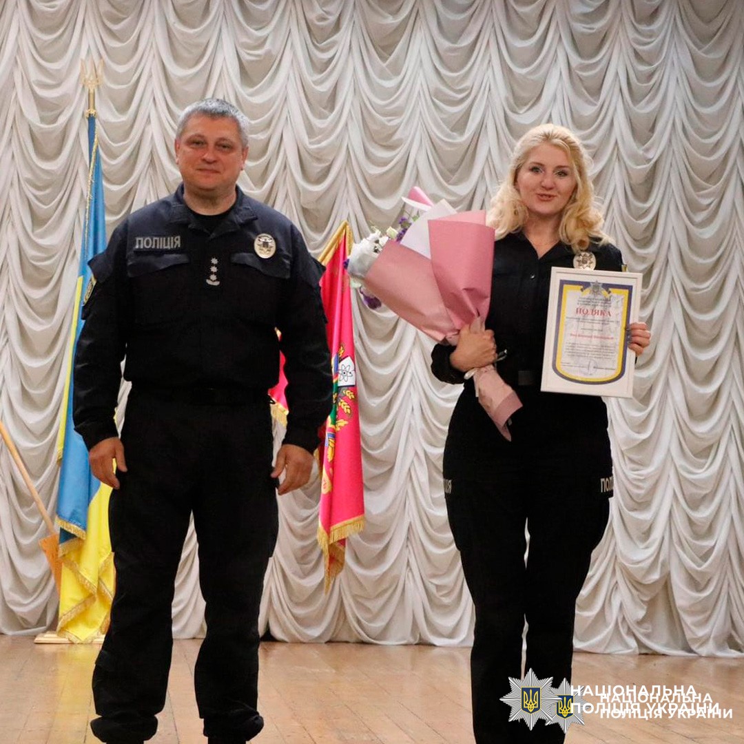 Поліцейська отримує подяку та квіти під час урочистої церемонії вшанування.