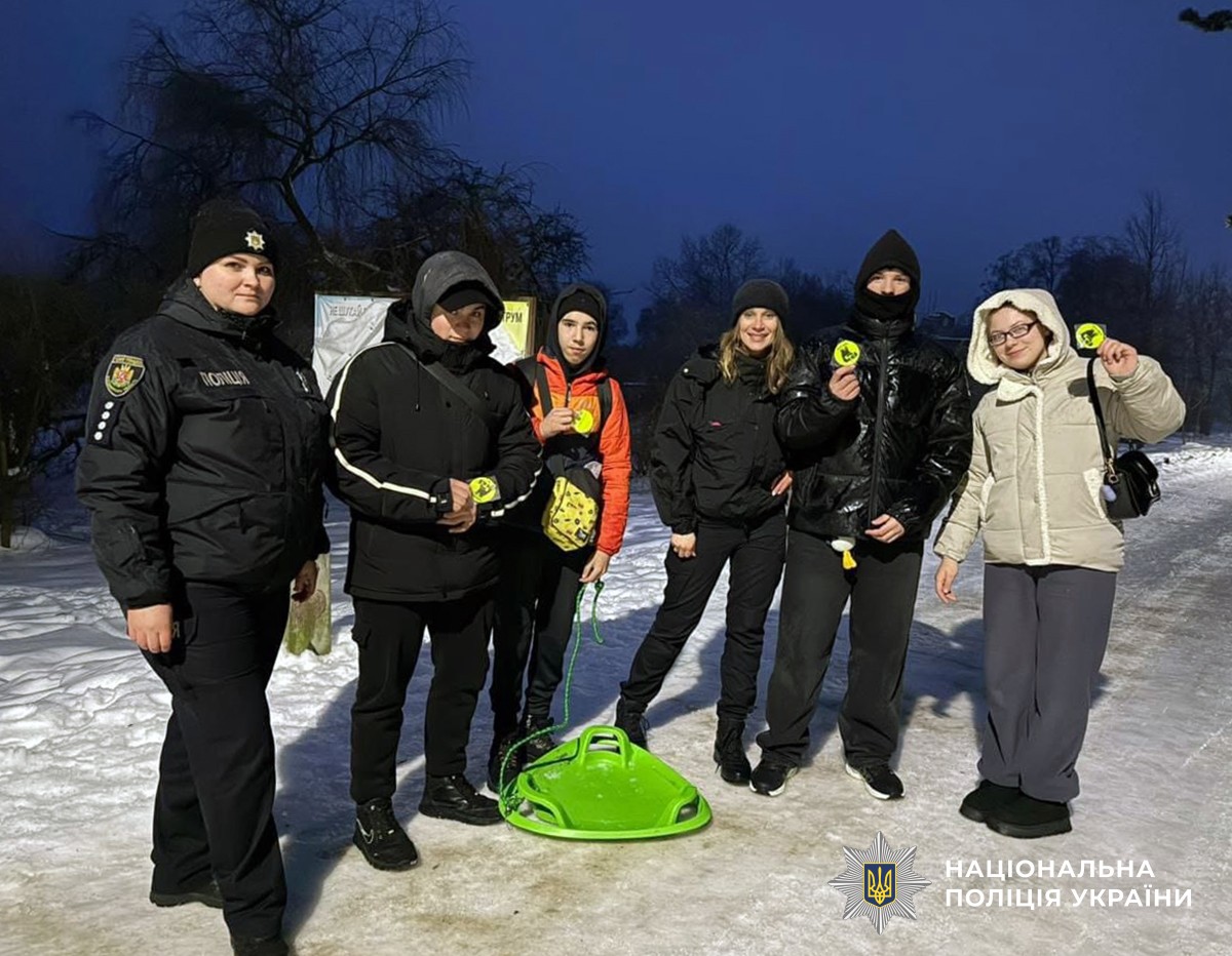 поліцейська та група людей з санчатами