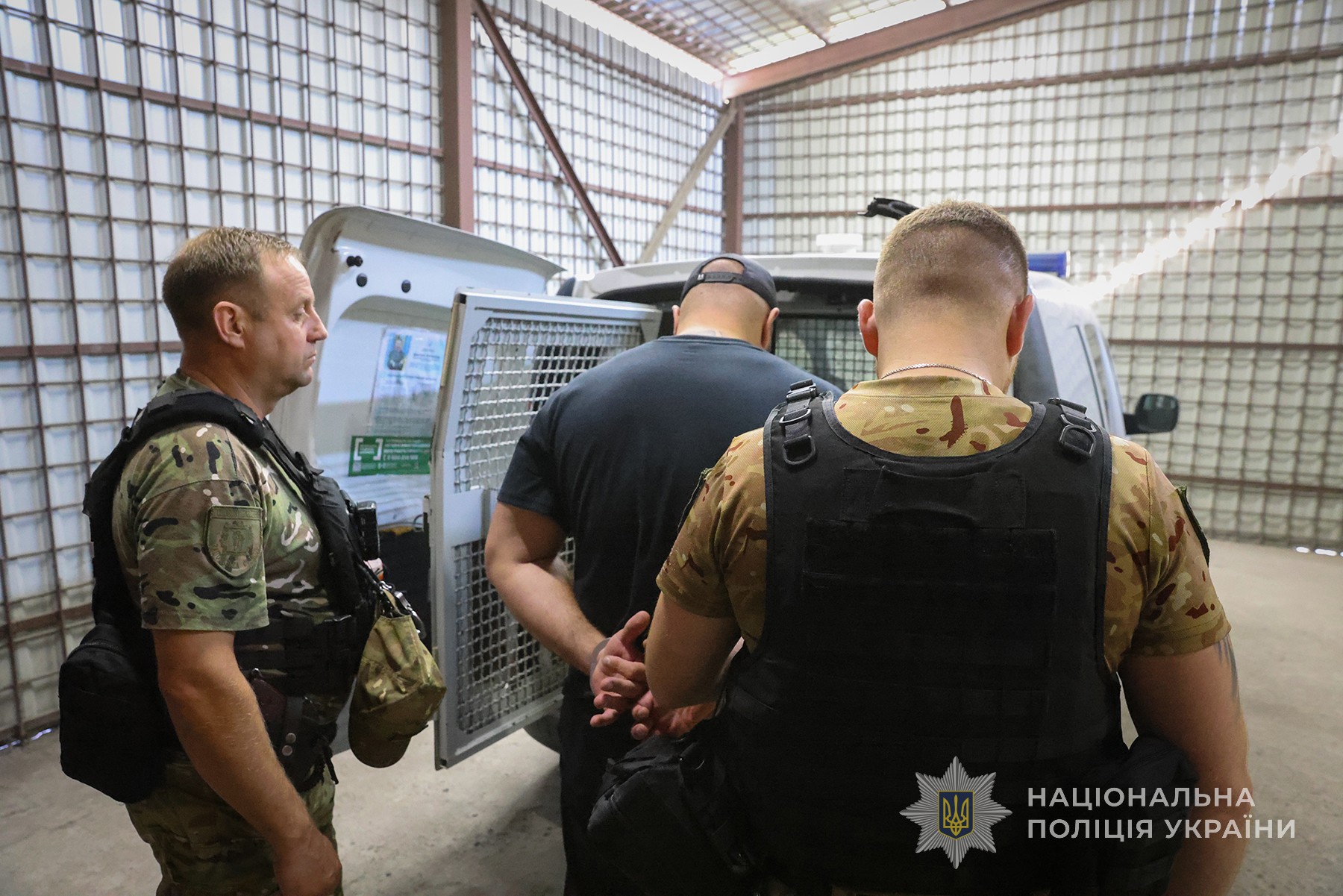 Поліцейські конвоюють організатора замаху на вбивство до судової установи для обрання йому запобіжного заходу. Місто Запоріжжя. Вересень 2025 року.