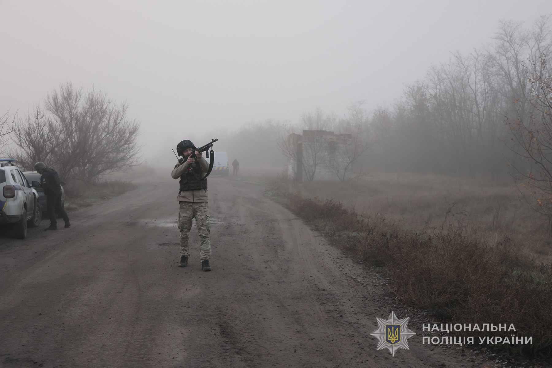 Поліцейський з помповою рушницею контролює небо для прикриття евакуаційної групи поліції від російських fpv-дронів. Околиці міста Гуляйполе. Листопад 2025 року.