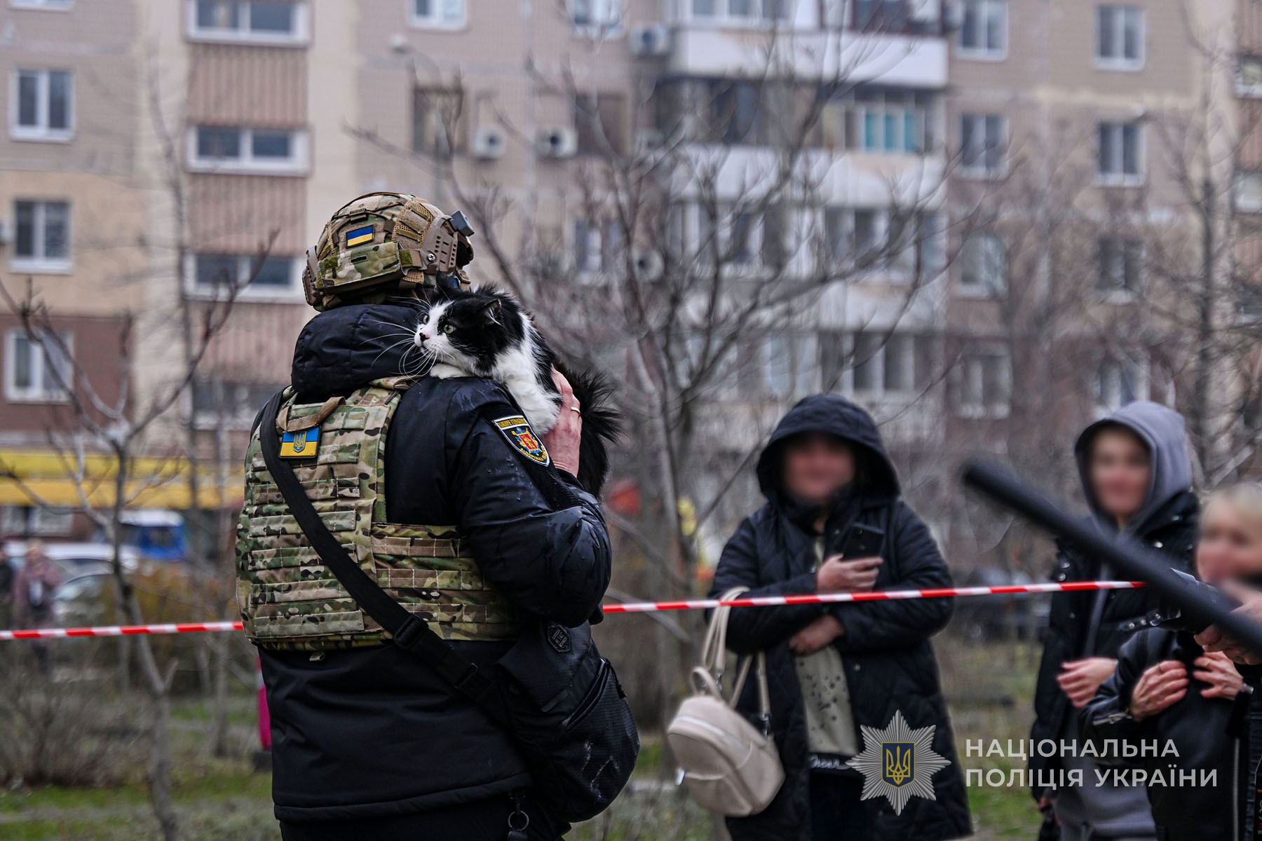 Запорізький поліцейський тримає кота, врятованого на місці російського авіаудару по багатоповерхівці в місті Запоріжжя. Грудень 2025 року.