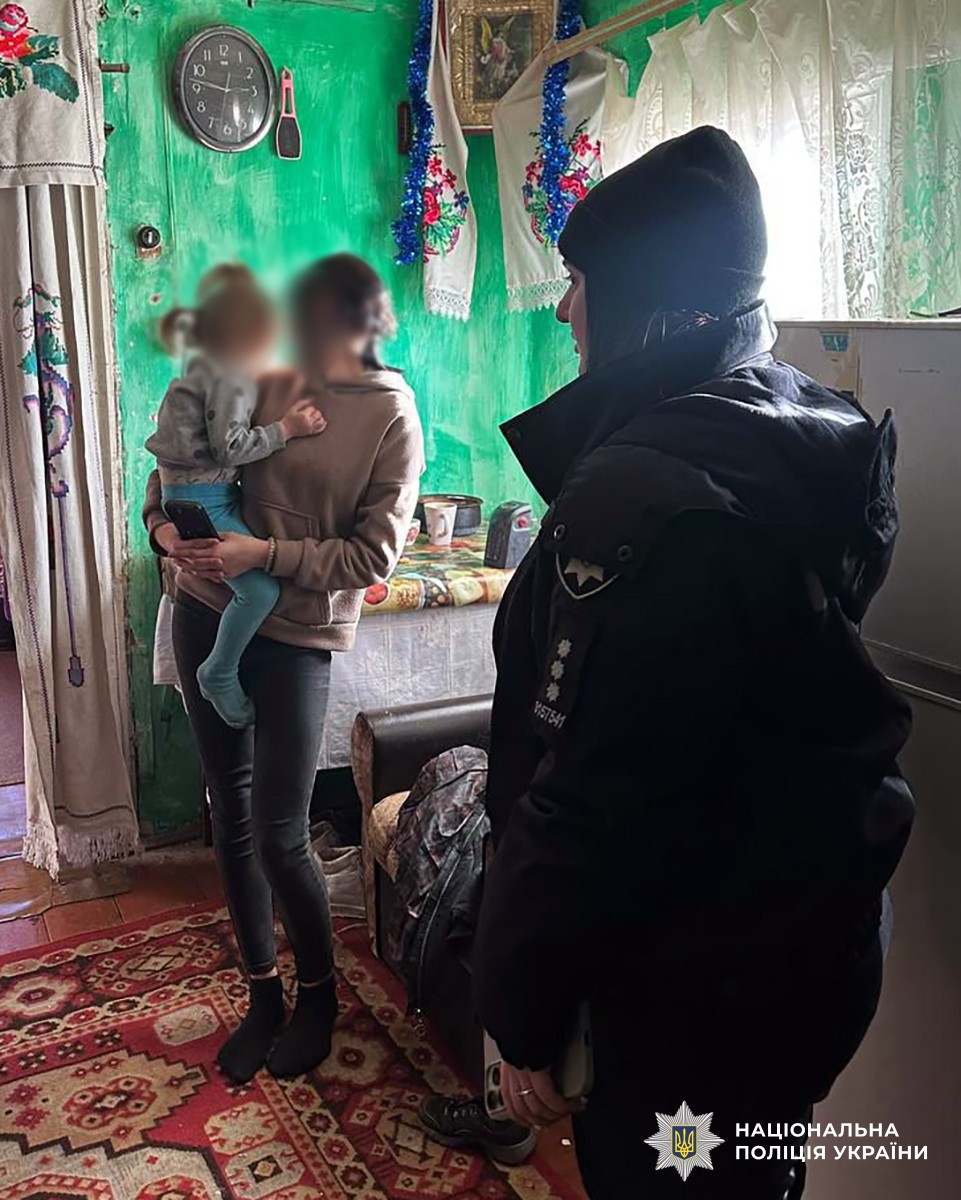 поліцейська в кімнаті з мамою, в якої на руках дитина