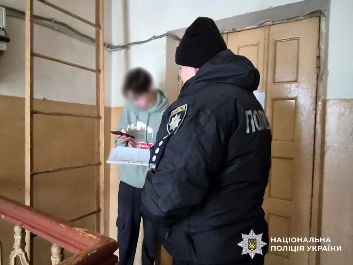 поліцейська спілкується з підлітком у під'їзді