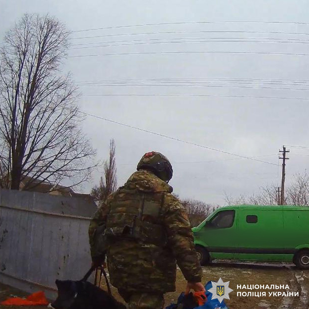 Працівник поліції несе речі евакуйованого чоловіка