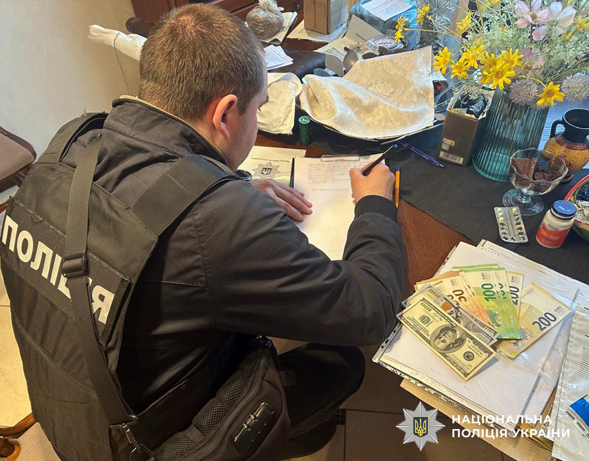 поліцейський вилучає кошти підозрюваного