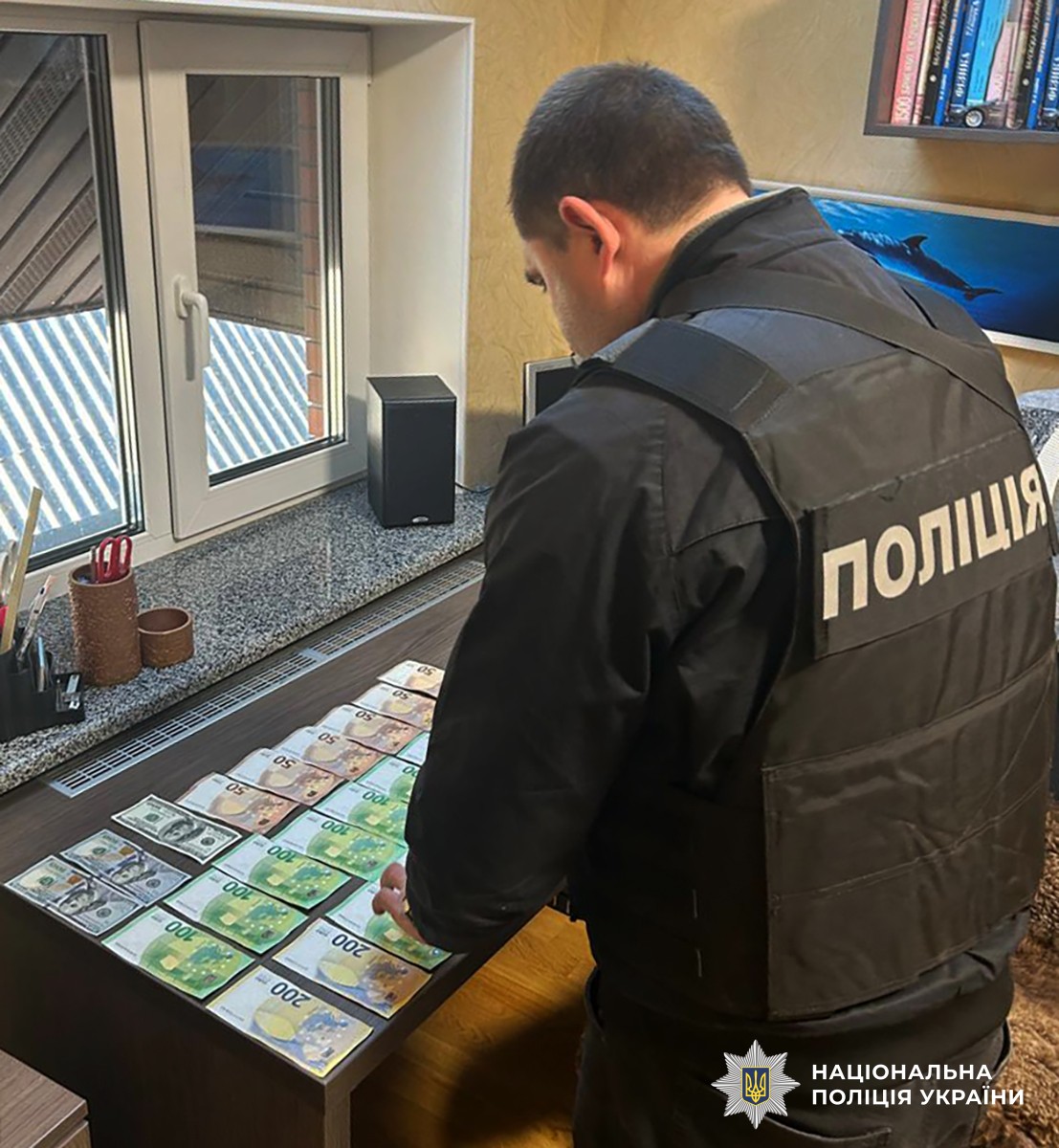 поліцейський вилучає кошти підозрюваного